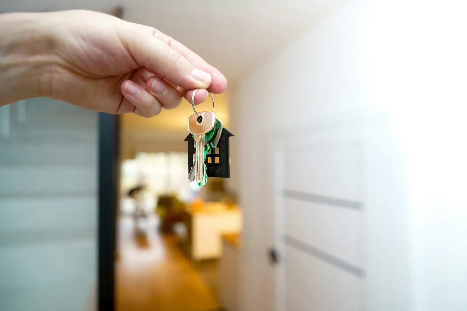 Hand holding house keys in a doorway
